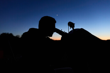 Amateur astronomer observing stars, planets, Moon and other celestial objects with a telescope in nature. © astrosystem