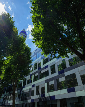 London - 07 14 2022: Howland Street modern patterned fa&ccedil;ade with BT Tower and trees