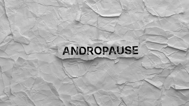 Crumpled piece of paper with word Andropause on torn crumpled white paper pieces background.