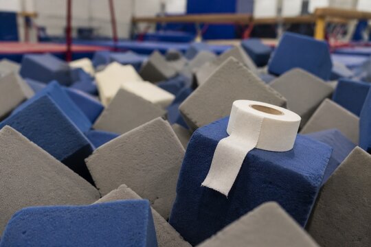 A pile of soft foam cubes in a gymnasium pit with athletic tape on top.