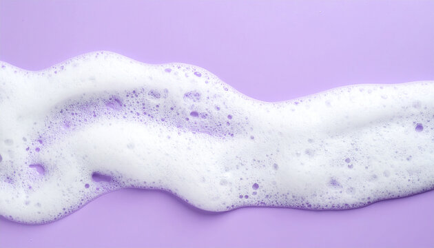 Soft soap foam texture with delicate shampoo bubbles on pastel purple background, hygiene and bath care concept, clean beauty aesthetic, minimal composition. Close-up.