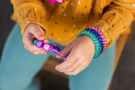 Little girl holding colourful chewelry bracelets for sensory stim