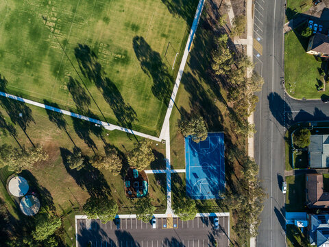 overhead aerial view of recreation area with park court and sports field by carpark