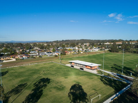 Alroy oval sports ground with new clubhouse building between fields