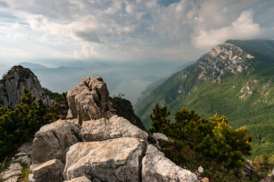 Mountain landscape with limestone cliffs overlooking Lake Garda, reflecting nature, adventure and tourism exploration on the Ventrar trail, Monte Baldo Natural Park, Brentonico,Trentino,Veneto Italy.