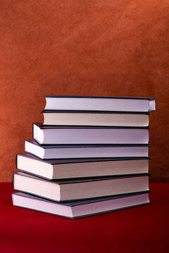Still life with stacked books on a colored background.