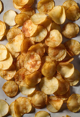 Fototapeta premium Overhead view of fresh potato chips scattered on white surface