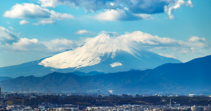 雪を頂いた美しい富士山と手前に広がる山並みの冠雪風景