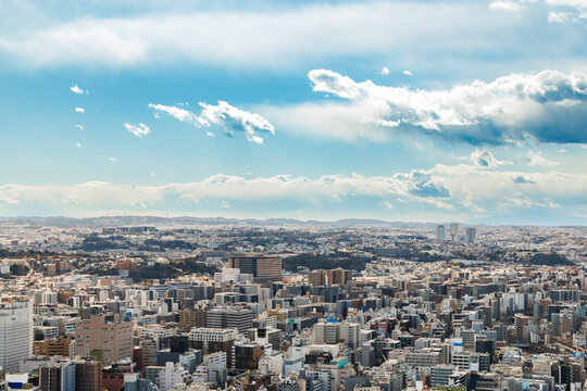 青空とダイナミックな雲が広がる都市の全景