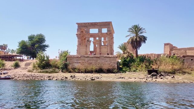 Ancient stone ruins of the philae temple complex on agilkia island in aswan, egypt. View from a boat moving along the famous nile river