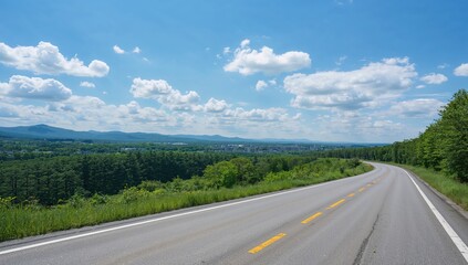 Fototapeta premium Winding Road Curving Through Lush Green Hills Under a Blue Sky with Clouds