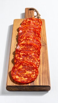 Sliced cured meat, rich red with white fat, artfully arranged on a wooden board