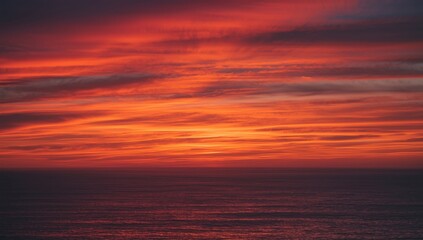 Fototapeta premium Vibrant Sunset Sky Over Calm Ocean Waters with Dramatic Cloud Patterns