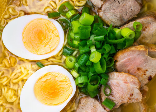 Ramen with duck, noodles and egg and green onion top view close up background, Asian noodle soup
