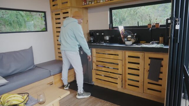 Man in sportswear cooking in a bachelor pad kitchen.