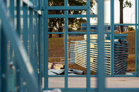 Blue steel frame of house under construction in Australian suburb at sunset
