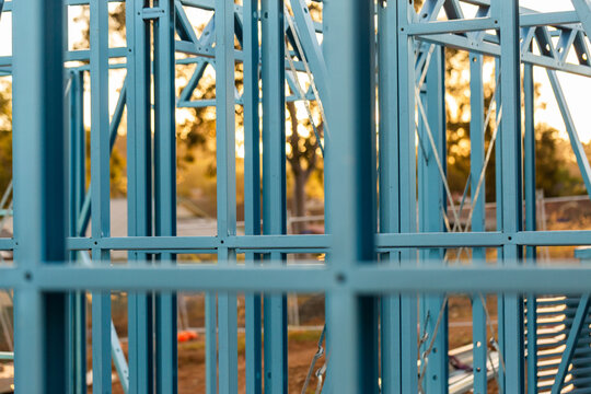 Blue steel frame of house under construction in Australian suburb at sunset
