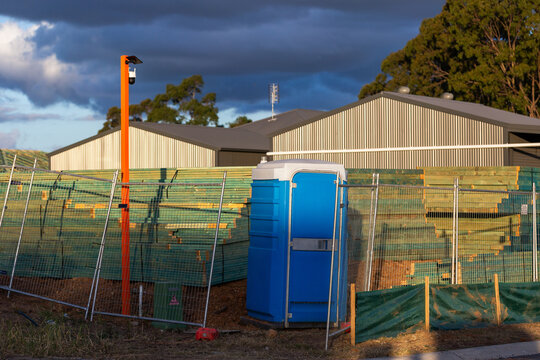 surveillance security camera by stockpiles at worksite by portaloo toilet