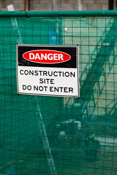green worksite fence with danger construction site do not enter sign