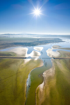 Aerial view of a disused railway bridge through a drying reservoir