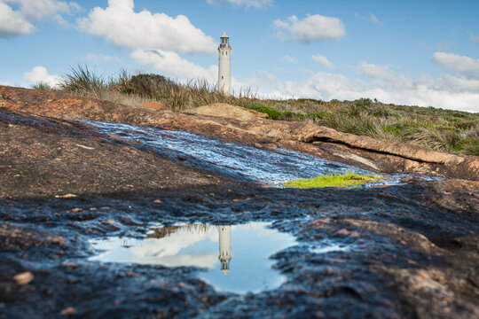 The historic Cape Leeuwin Lighthouse reflected in a coastal rockpool