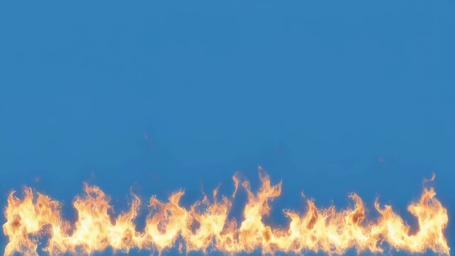Continuous horizontal fire line burning across a clear blue sky with a black foreground