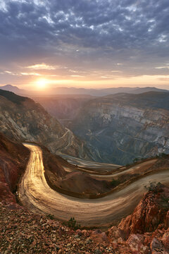 A Grand View of a Wide Open-Pit Mine with winding paths and striking skies
