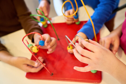 Children engage in motor skill development with a bead maze toy, pediatric physiotherapy session, rehabilitation exercises for fine motor skills, sensory play, and hand-eye coordination