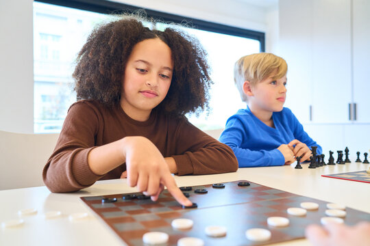 Children playing checkers and chess, pediatric rehabilitation center, therapist with children, balance training, physical therapy session, motor skills training