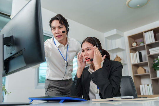 Asian customer service agents experiencing technical difficulties in call center