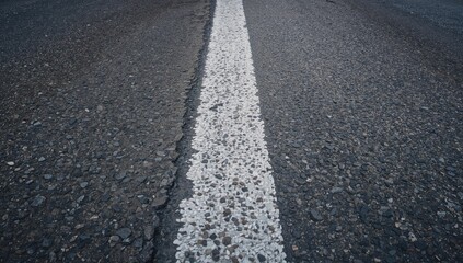 Obraz premium Closeup of a White Road Stripe on Asphalt Pavement