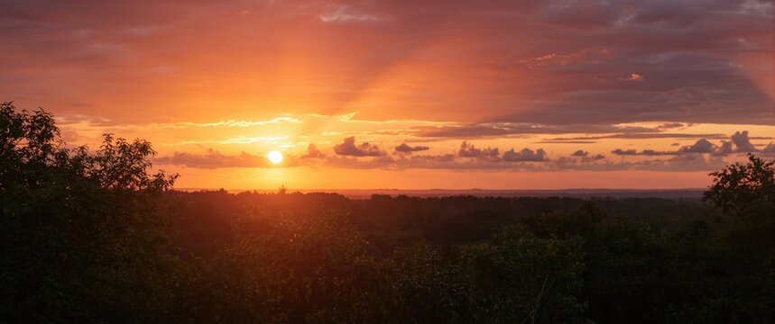 Sunset Over Rolling Hills with Dramatic Cloudscape and Warm Light