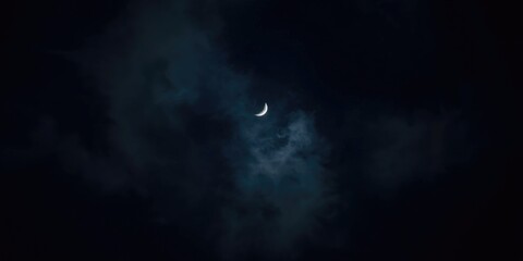 Fototapeta premium Crescent Moon Shining Through Dark Clouds - Night Sky, Mysterious Atmosphere