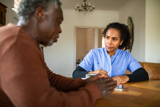 Nurse consulting with senior patient at home