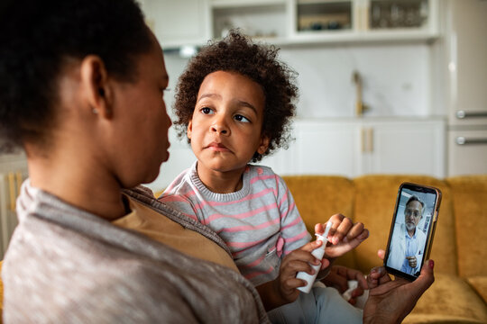 Mother and child on telemedicine video call at home
