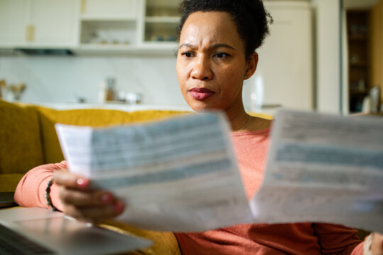 Concerned woman reviewing household bills at home