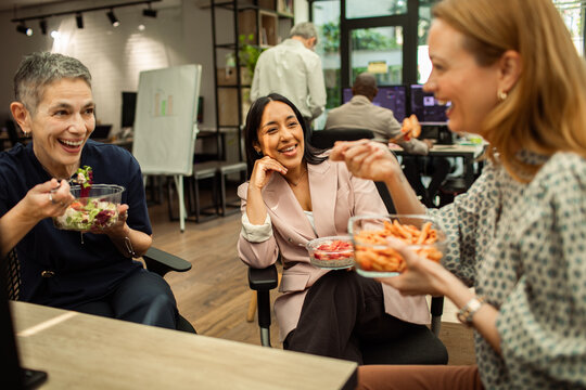 Coworkers enjoying healthy lunch break in modern office