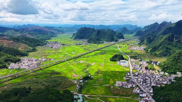 Summer High-Speed Train Passing Karst Rice Fields with Mixed Green and Yellow Crops
