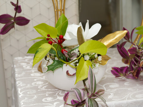 Composition florale &eacute;l&eacute;gante avec rose blanche, feuillage d&eacute;coratif et fleurs blanches sur table de r&eacute;ception de mariage