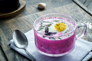 Chilled vegetable soup with sour cream and herbs in clear mug © Yingko