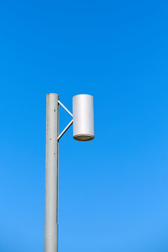 Close-up of a modern lamppost with a clear blue sky.
