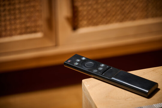 Close-up of a television remote control resting on a table.