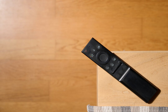 Close-up of a television remote control resting on a table.