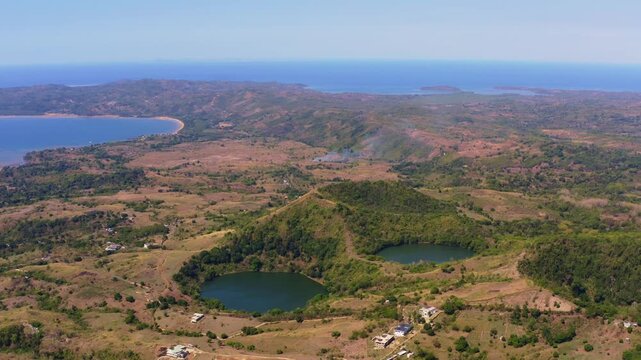 4K drone wide shot capturing the volcanic crater lakes and the distant coastline of Nosy Be Madagascar.