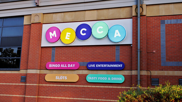 Leicester, England, UK - 12 July 2026: Mecca Bingo club entrance sign on red brick wall, British gambling venue facade, colorful corporate logo for slots and live entertainment hall, UK betting