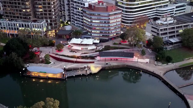 Zoom in to Parramatta city river wharf in Western Sydney CBD aerial sunset view.