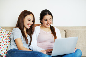 Fototapeta premium Friends, smile or teens on sofa with laptop, watching movie or online entertainment in hangout. Space, digital or girls in home with tech, bonding together or series streaming on multimedia platform.