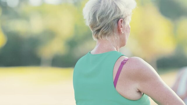 Senior woman practicing tai chi in park during summer