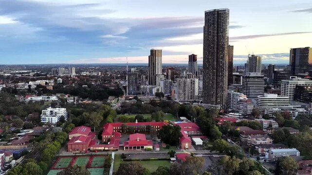 School campus to Western Sydney stadium in aerial panorama of Parramatta city CBD.