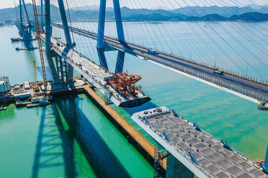 Aerial view of a modern cable-stayed bridge under construction showing heavy machinery and engineering progress, Ningbo, China